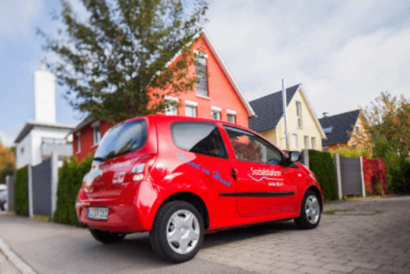 Ein rotes Auto mit der Aufschrift Sozialstation Lindau.
